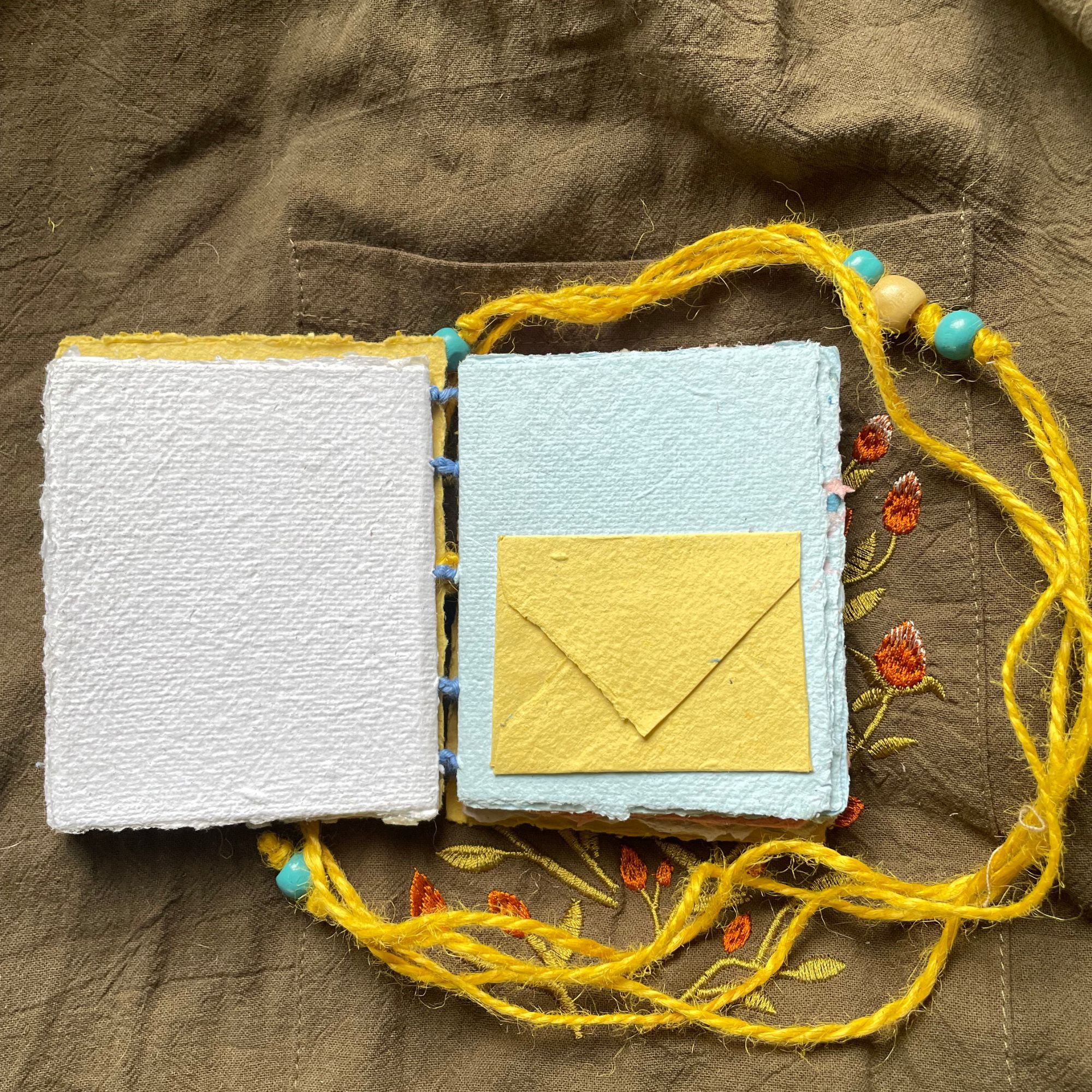 Daybreak handmade paper pocket journal opened to show tactile handmade pages