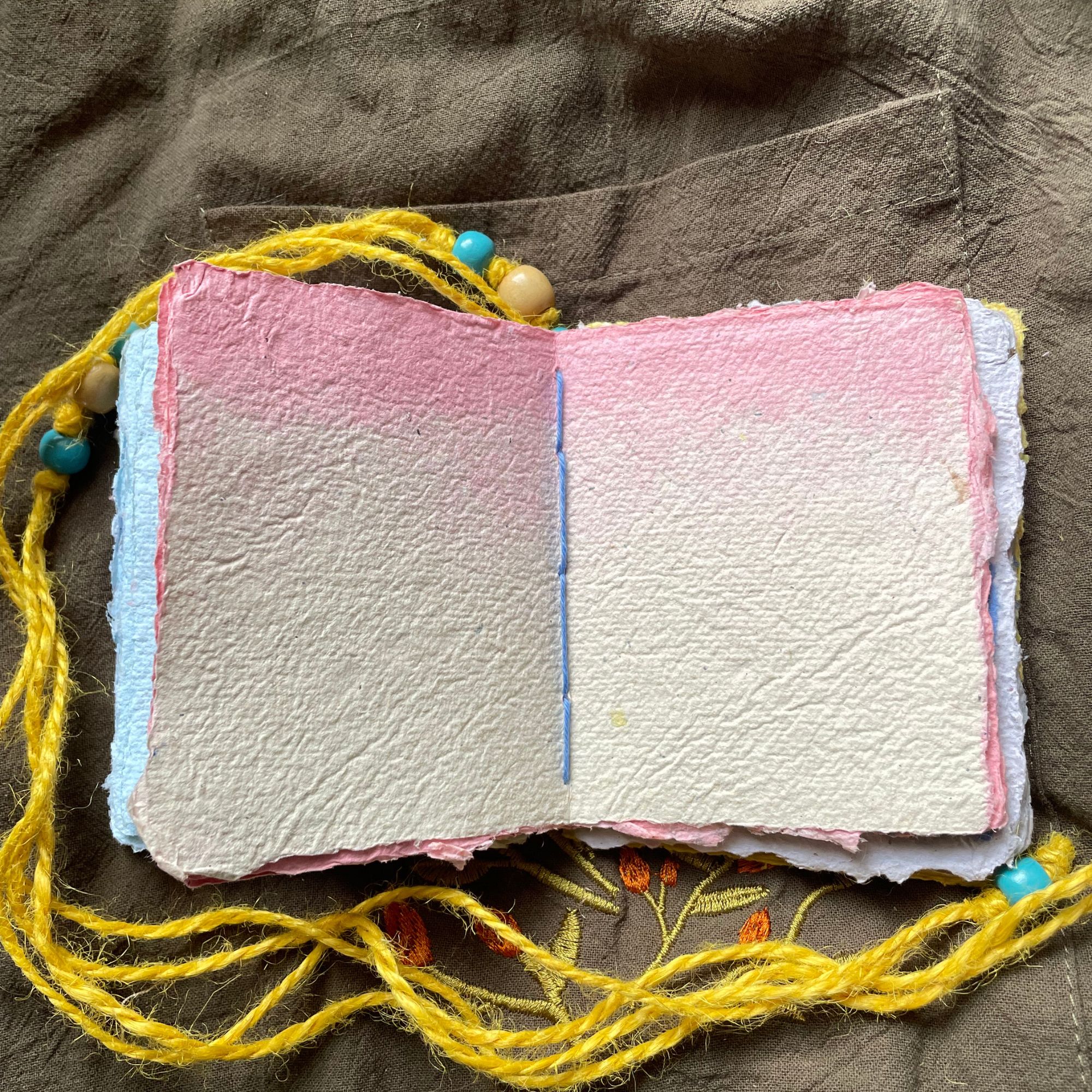 Daybreak handmade paper pocket journal opened to show tactile handmade pages