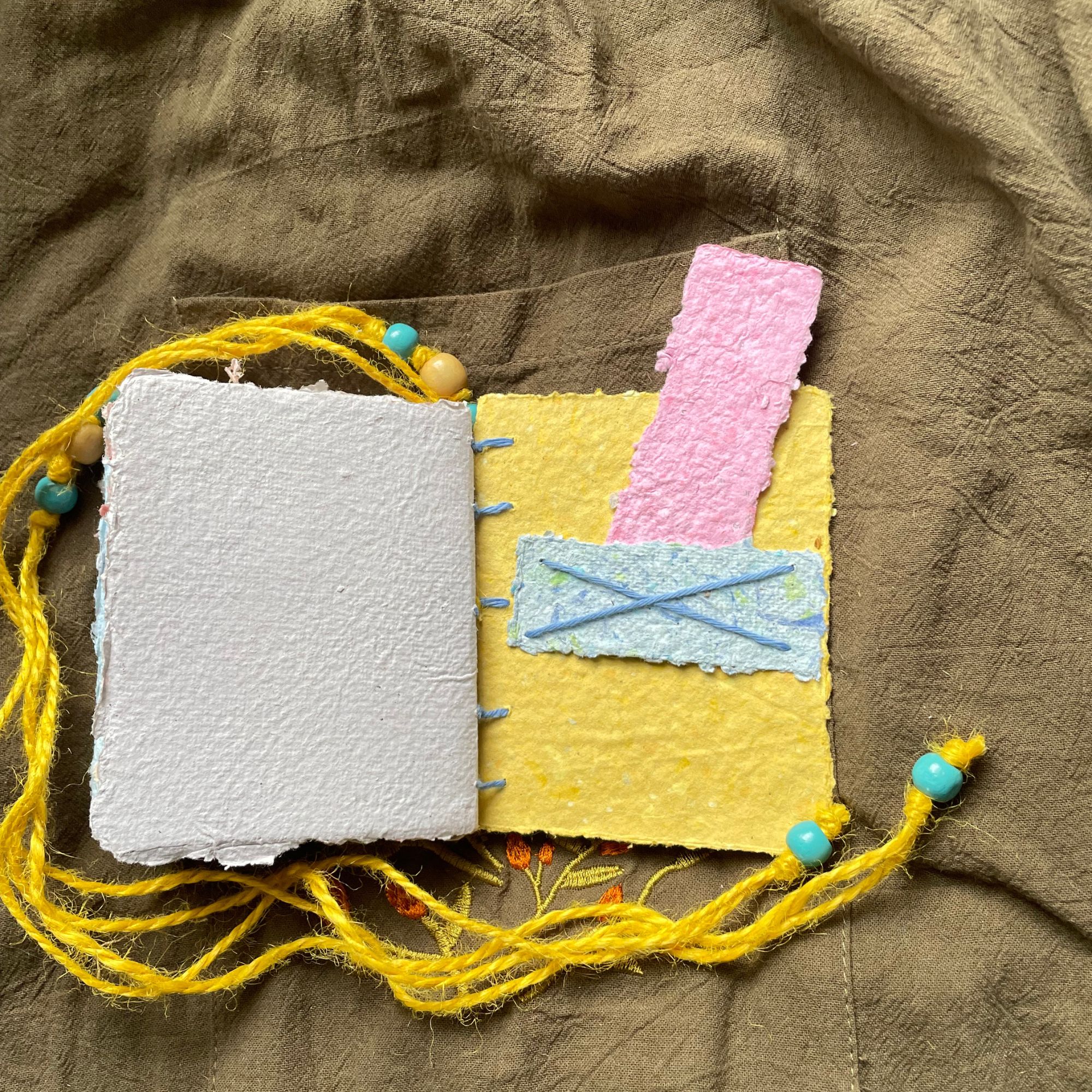 Daybreak handmade paper pocket journal opened to show tactile handmade pages