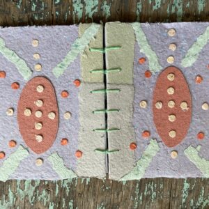 Coptic stitch binding with handmade paper collage covers. Notebook lying flat and open